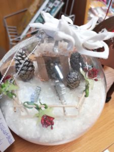 Na zdjęciu: Kula a w niej sztuczny śnieg, szyszki i ozdoby bożonarodzeniowe.