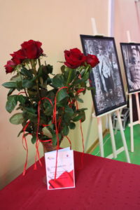 Na zdjęciu: Bukiet czerwonych róż. W tle zdjęcia Józefa Piłsudskiego na sztalugach.