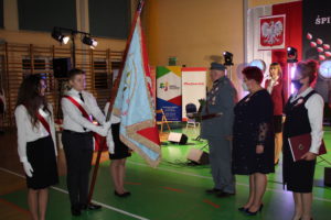Na zdjęciu: Poczet sztandarowy oraz trzy kobiety i meżczyzna w wojskowym mundurze.