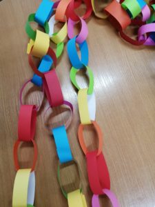 Na zdjęciu: Kolorowy łańcuch, wykonany z połączenia pasków papierowych w oczka.