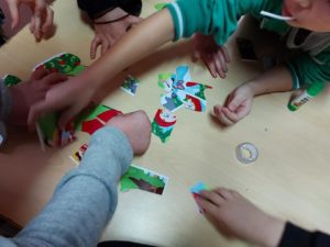 Na zdjęciu: Ręce dzieci układające puzzle.