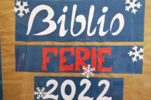 Biało - czerwony napis: BIBLIOFERIE 2022 ozdobiony płatkami śniegu.