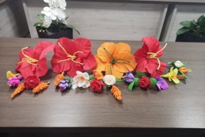 Na zdjęciu: Kwiaty z krepiny wykonane podczas warsztatów. Trzy duże czerwone i jeden pomarańczowy oraz kilkanaście kolorowych małych.