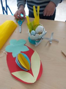 Na zdjęciu: papierowe kolorowe, jajko i koszyczek ze styropianowymi jajeczkami.