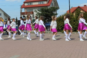 Na zdjęciu: Tańczące dziewczynki w białych bluzkach, różowych spódnicach i białych długich skarpetkach.