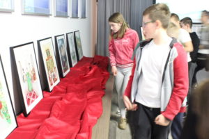 Na zdjęciu: Dzieci oglądają kolorowe ilustracje w czarnych ramach