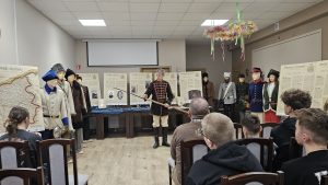 Prowadzący spotkanie prezentuje eksponaty grupie uczestników