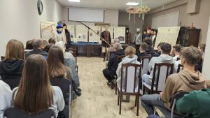 Prowadzący spotkanie prezentuje eksponaty grupie uczestników