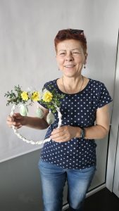 Uczestniczka warsztatów prezentuje własnoręcznie wykonany wianek