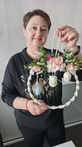 Uczestniczka warsztatów prezentuje własnoręcznie wykonany wianek