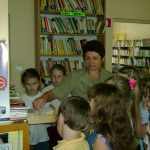 Bibliotekarz uczy dzieci korzystania z kartkowego katalogu bibliotecznego