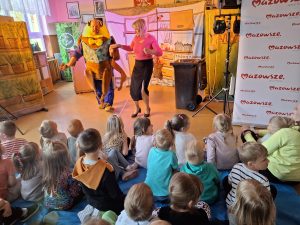 Dzieci, nauczyciel i akrtor podczas spektaklu teatralnego "Śmiecio Eko Baja"
