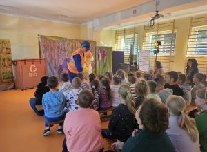 Dzieci i nauczyciele i aktorzy podczas spektaklu teatralnego "Śmiecio Eko Baja"
