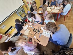 Grupa kobiet i dzieci malujących kamyki