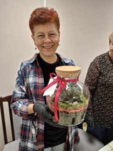Kobieta z dużym słojem, w którym są małe roślinki