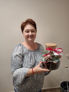 Kobieta z dużym słojem, w którym są małe roślinki
