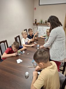 Dzieci oraz opiekun w trakcie zajęć w bibliotece