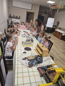 Dzieci i instruktorka podczas warsztatów drukarskich