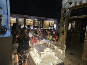 Grupa dzieci zwiedzających muzeum wraz z prowadzącą
