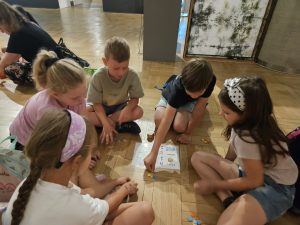Grupa dzieci grających w grę w muzeum