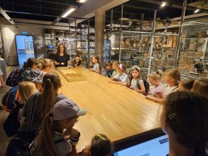 Grupa dzieci podczas gry w muzeum wraz z prowadzącą