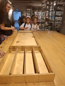 Grupa dzieci podczas gry w muzeum wraz z prowadzącą