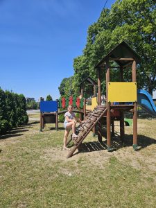 Dziewczynka wchodzi na zjeżdżalnię, na placu zabaw
