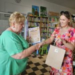 Dyrektor biblioteki wręcza nagrodę laureatce konkursu na Najlepszego Czytelnika Wakacji 2025