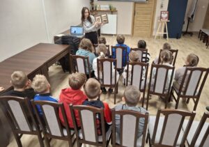 20251113_091605(0) Kobieta pokazująca dzieciom książkę