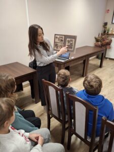 20251113_091702 Kobieta pokazująca dzieciom książkę
