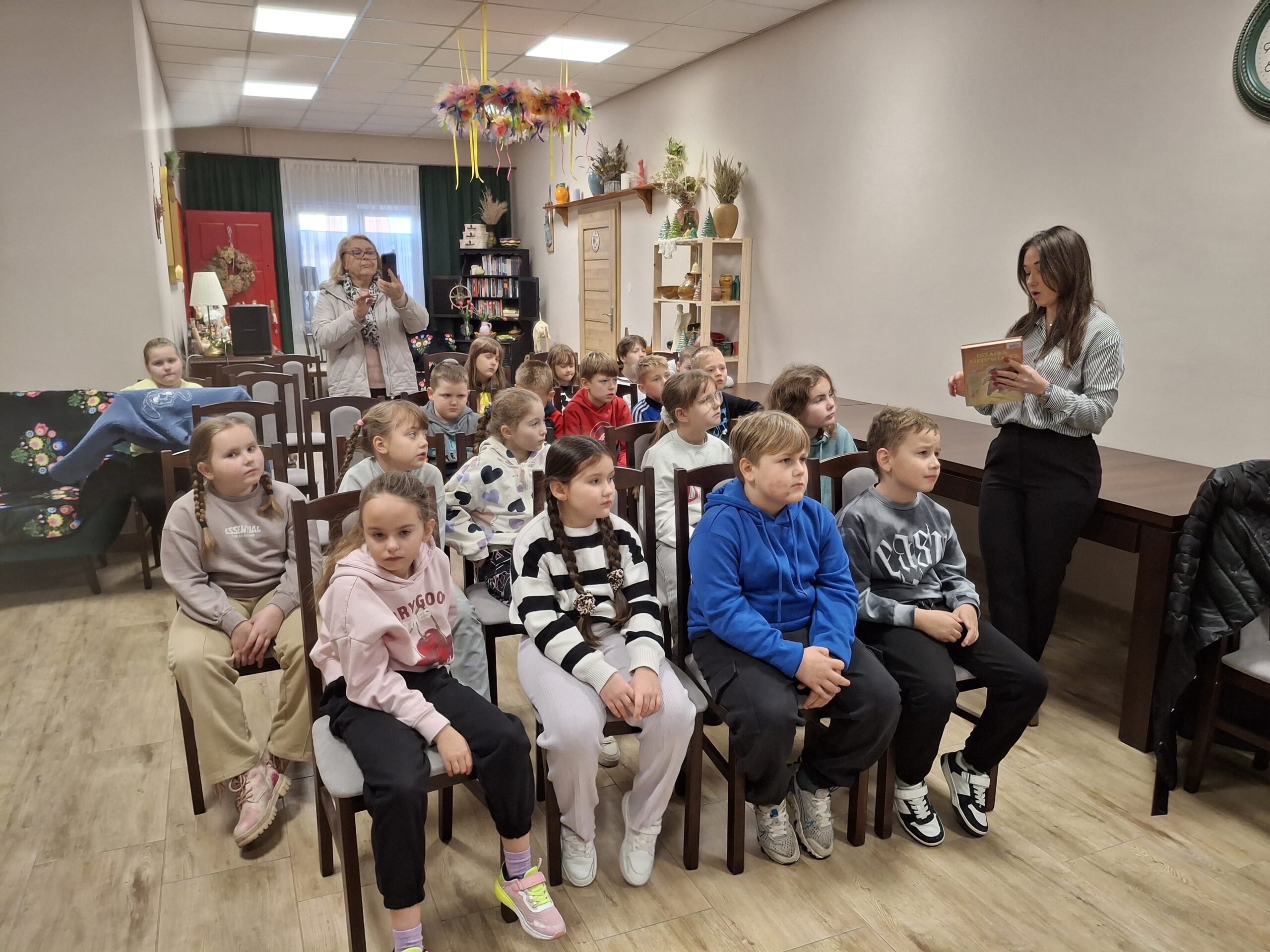 20251113_091759 Kobieta pokazująca dzieciom książkę