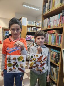 20251113_154332 Dwaj chłopcy, trzymający obrazki z ptaszkami z kasztanów.