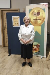 Kobieta stojąca na tle baneru - Jakuboteka