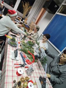 Kobiety podczas warsztatów robienia wianków świątecznych.