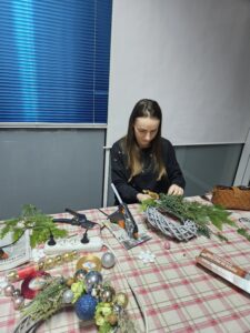 Kobieta robiąca świąteczny wianek.