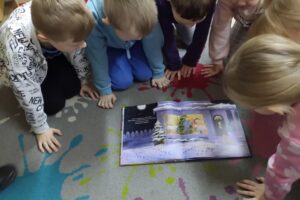 Dzieci oglądające książkę.