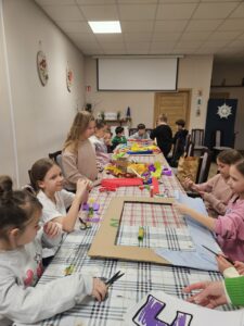 Dzieci ozdabiają ramy podczas warsztatów.