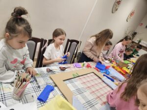 Dzieci ozdabiają ramy podczas warsztatów.