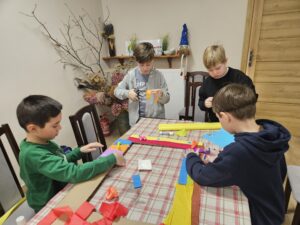 Chłopcy ozdabiają ramy podczas warsztatów.