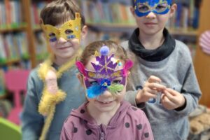 Troje dzieci w maskach karnawałowych.