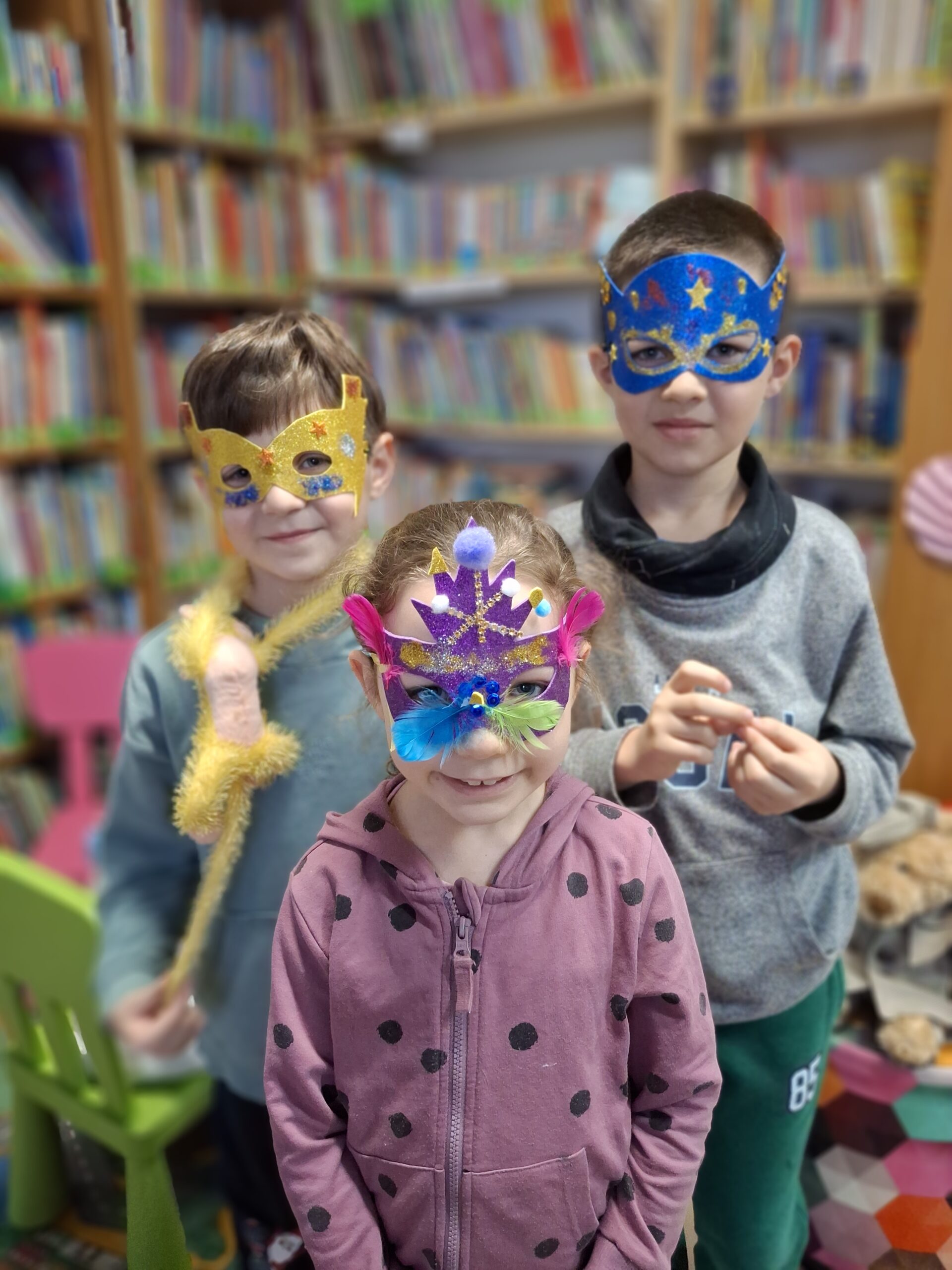 Troje dzieci w maskach karnawałowych.