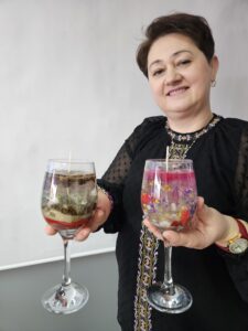 20260214_114748 Kobieta trzymająca w ręku dwie świece żelowe w kielichach.