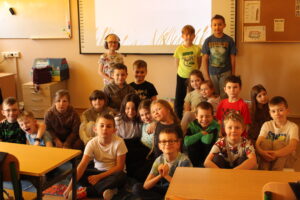 IMG_0500 Dzieci siedzą na dywanie i oglądają bajkę animowaną.