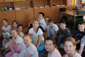 IMG_0502 Dzieci siedzą na dywanie.