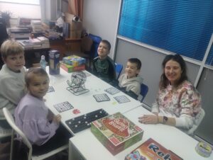 Dzieci i instruktorka podczas gier planszowych.