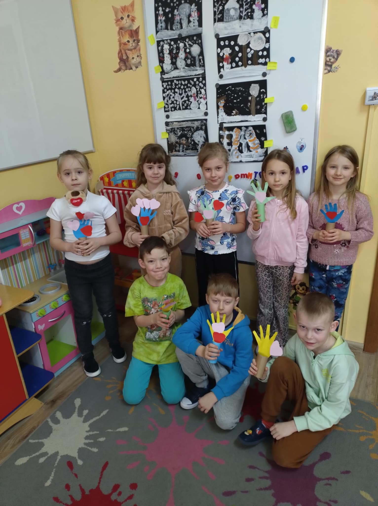 Grupa dzieci z papierowymi drzewkami.