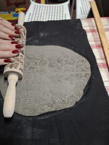 Wałkowanie gliny, wałkiem z ornamentem.