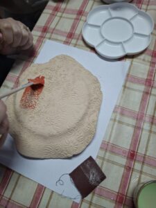 Gliniana miseczka podczas szkliwienia.