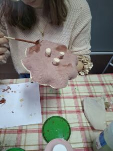 Gliniana miseczka podczas szkliwienia.