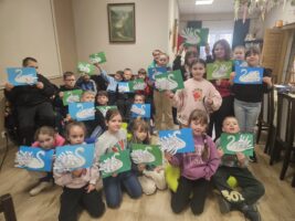 Grupa dzieci prezentująca swoje prace plastyczne - łabędzie.